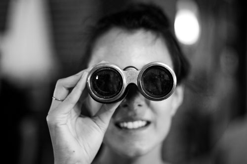 Woman searching with binoculars.